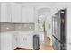 Kitchen with white cabinets, light countertops, stainless steel refrigerator and access to living space at 3153 Pinehills Way, Mount Holly, NC 28120