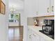 Bright kitchen features white cabinets, light countertops, stainless steel appliances and open view to the dining area at 3153 Pinehills Way, Mount Holly, NC 28120