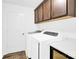 Convenient laundry room with modern washer and dryer, plus overhead cabinets for optimal storage solutions at 3153 Pinehills Way, Mount Holly, NC 28120