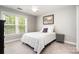 Bright bedroom featuring a large window, ceiling fan, and a comfortable bed with white linens at 3306 Delamere Dr, Matthews, NC 28104