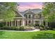 Charming two-story brick home featuring manicured lawn, black shutters, and inviting front entrance at 3306 Delamere Dr, Matthews, NC 28104