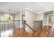 Hallway featuring hardwood floors, wrought iron railing, and natural light at 3306 Delamere Dr, Matthews, NC 28104