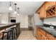 Basement kitchenette with stainless steel appliances, bar seating, and wooden cabinetry at 3306 Delamere Dr, Matthews, NC 28104
