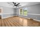 Spacious bedroom with wood floors, natural light from windows, and modern ceiling fan at 3546 Mount Pleasant N Rd, Concord, NC 28025