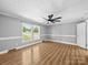 A spacious bedroom featuring wood-look flooring, neutral paint, and bright natural light at 3546 Mount Pleasant N Rd, Concord, NC 28025