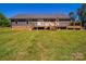 Back exterior of the house featuring a deck and large grassy yard at 3546 Mount Pleasant N Rd, Concord, NC 28025