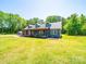 Charming blue home with a covered porch and mature trees, set on a sunny lot with green grass at 3546 Mount Pleasant N Rd, Concord, NC 28025