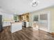 Open concept kitchen with island, stainless steel appliances, wood accent wall, and access to outdoor deck at 3546 Mount Pleasant N Rd, Concord, NC 28025