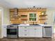 Bright kitchen featuring a wood accent wall, stainless steel appliances, and white cabinets with stone countertops at 3546 Mount Pleasant N Rd, Concord, NC 28025