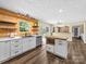 Bright open kitchen with island, stainless steel appliances, wood accent wall, and modern cabinetry at 3546 Mount Pleasant N Rd, Concord, NC 28025