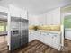 Bright kitchen featuring stainless steel refrigerator and white cabinets with modern hardware and wood floors at 3546 Mount Pleasant N Rd, Concord, NC 28025