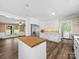 Modern kitchen boasts white cabinets, stainless steel appliances, butcher block island, and open floor plan at 3546 Mount Pleasant N Rd, Concord, NC 28025