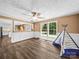 Living room with large windows, wood floors, and passthrough to modern kitchen at 3546 Mount Pleasant N Rd, Concord, NC 28025