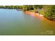 Scenic view of the beach area with a sandy shoreline, green grass and picnic benches on the shore at 4160 Isle Of Pines Dr, Denver, NC 28037