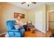 Comfortable bedroom showcasing a blue recliner chair, wooden floors, and soft, warm lighting at 4160 Isle Of Pines Dr, Denver, NC 28037