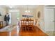 Warm dining room with hardwood floors, wainscoting, a charming light fixture, and a view of the front entrance at 4160 Isle Of Pines Dr, Denver, NC 28037
