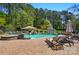 Inviting pool and spa surrounded by a brick patio, lounge chairs, waterfall feature and lush landscaping at 4160 Isle Of Pines Dr, Denver, NC 28037