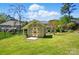 A well-maintained shed in a spacious backyard with lush green grass and a partial view of the main house at 4160 Isle Of Pines Dr, Denver, NC 28037