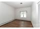 Minimalist bedroom featuring wood floors, white walls, and a window for natural light at 455 W Gleneagles Rd, Statesville, NC 28625