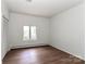 Cozy bedroom with sleek wood flooring, white walls, and a window offering natural light at 455 W Gleneagles Rd, Statesville, NC 28625