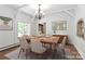 Dining room with vaulted ceilings, modern chandelier, wood table and seating for six at 455 W Gleneagles Rd, Statesville, NC 28625