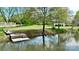 Picturesque dock on the lake, featuring a bench and a boat, surrounded by serene water and greenery at 455 W Gleneagles Rd, Statesville, NC 28625