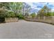Long paved driveway to home, bordered by attractive beige brick and masonry privacy wall and spring trees at 455 W Gleneagles Rd, Statesville, NC 28625