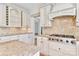 Kitchen area features Viking gas range, travertine backsplash, granite countertops and white cabinets at 455 W Gleneagles Rd, Statesville, NC 28625