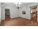 Open-concept living space featuring traditional chandelier and decorative wall cut-out at 455 W Gleneagles Rd, Statesville, NC 28625