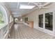 Spacious sunroom with tiled floors, arched windows offering natural light, and a ceiling fan at 455 W Gleneagles Rd, Statesville, NC 28625