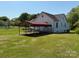 Backyard view of the home, featuring a carport and a spacious lawn at 4787 Rock Barn Rd, Claremont, NC 28610