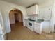 Traditional kitchen with white cabinets, appliances, and arched doorway at 4787 Rock Barn Rd, Claremont, NC 28610