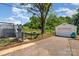 A bright backyard with a lush lawn, mature trees, a deck, and detached garage at 504 N Hawthorne St, Mount Holly, NC 28120
