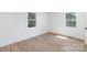 Bright, vacant bedroom features hardwood floors and two windows providing lots of natural light at 5514 Milford Rd, Charlotte, NC 28210