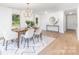 Bright dining area features modern light fixture, seating for six, and view to console table at 5514 Milford Rd, Charlotte, NC 28210