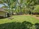 A large lush backyard with mature trees and a garden on a sunny day at 5601 Londonderry Rd, Charlotte, NC 28210