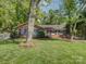 Charming brick home with well-maintained lawn, mature trees, and black shutters at 5601 Londonderry Rd, Charlotte, NC 28210