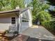 A detached garage, painted white, with an access door and an automatic garage door at 5601 Londonderry Rd, Charlotte, NC 28210