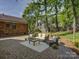 A brick patio with outdoor furniture, set in a green lawn, and a view of the brick house at 5601 Londonderry Rd, Charlotte, NC 28210