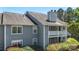 A gray two-story home showcasing a balcony with decorative lattice and surrounding greenery at 6053 Treetop Ct, Charlotte, NC 28212