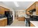 Well-lit kitchen featuring wooden cabinets, modern appliances, and a connecting dining room at 6053 Treetop Ct, Charlotte, NC 28212