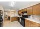 Kitchen features wooden cabinets, appliances, a view to the dining room, and durable tile flooring at 6053 Treetop Ct, Charlotte, NC 28212