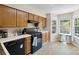 Functional kitchen equipped with appliances, wooden cabinets, and natural light from the corner windows at 6053 Treetop Ct, Charlotte, NC 28212