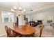 Open concept living room with fireplace next to dining area with chandelier and wood table at 6053 Treetop Ct, Charlotte, NC 28212