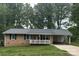 Charming brick home with a covered porch and carport, nestled amongst mature trees at 609 E Maine Ave, Bessemer City, NC 28016