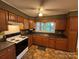 Functional kitchen with wood cabinets, black appliances, and laminate countertops at 609 E Maine Ave, Bessemer City, NC 28016