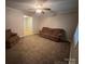 Neutral living room with carpet, a ceiling fan, and a comfortable brown sofa at 609 E Maine Ave, Bessemer City, NC 28016