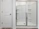 A new white shower stall with glass doors, shelving, and bright lighting at 6157 Helens Rest Ln, Lincolnton, NC 28092