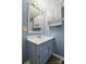 This blue bathroom features a vanity, a mirror with lights and overhead storage with a towel rack at 621 Harper Davis Rd, Lake Wylie, SC 29710