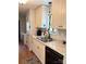 Farmhouse kitchen sink with white cabinets, grey countertops and black appliances at 6212 Sunset Cir, Charlotte, NC 28216